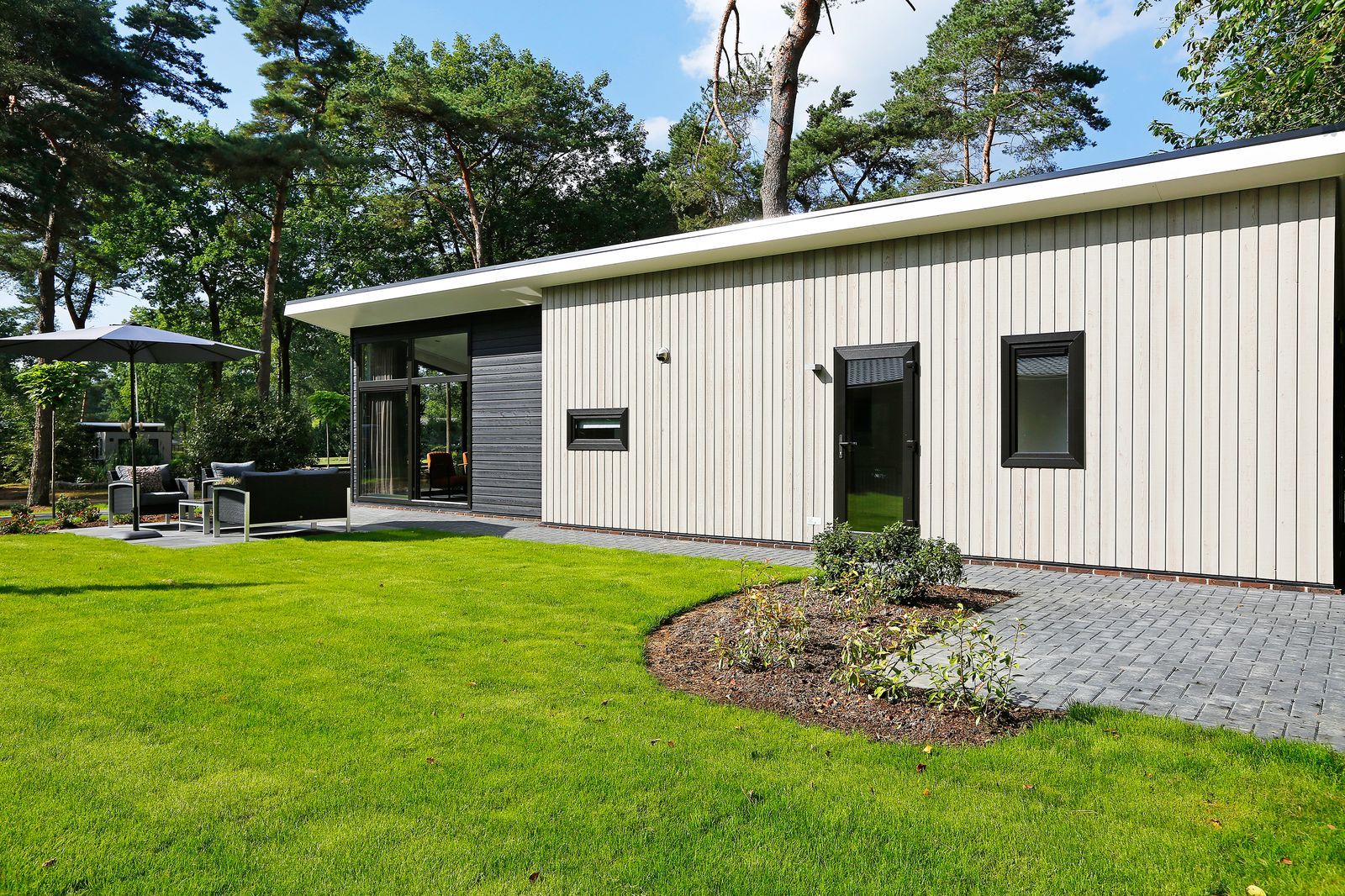 Donkere boslodge tussen hoge bomen